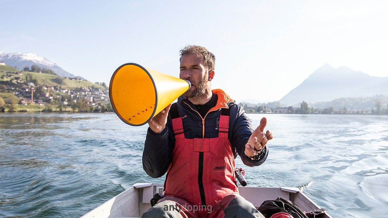 Ein Mann auf einem Boot, der in ein Megaphon spricht