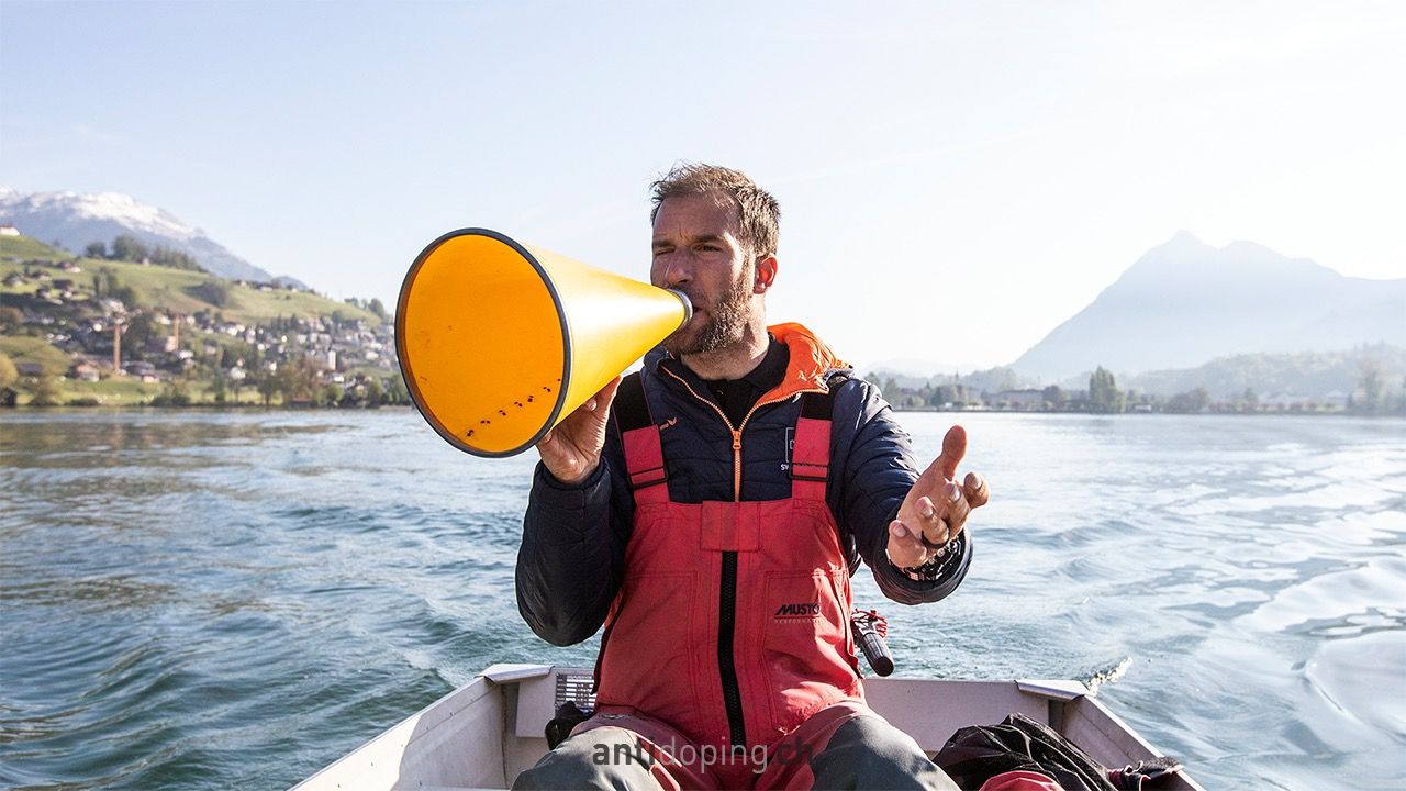 Un homme sur une barque et parlant dans un megaphone