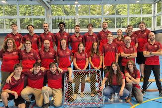 Les nouvelles monitrices J+S et nouveaux moniteurs J+S posent avec les expert·e·s J+S qui les ont formés dans une salle de sport, sur trois rangées et avec un cadre de tchoukball.