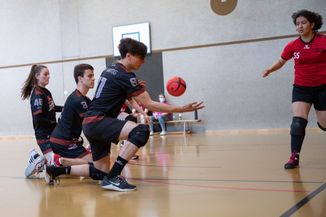 Trois joueurs en défense avec une balle en suspension